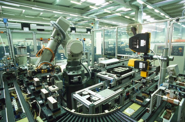 Robot assembling electronic components --- Image by © Michael Rosenfeld/Maximilian S/SuperStock/Corbis
